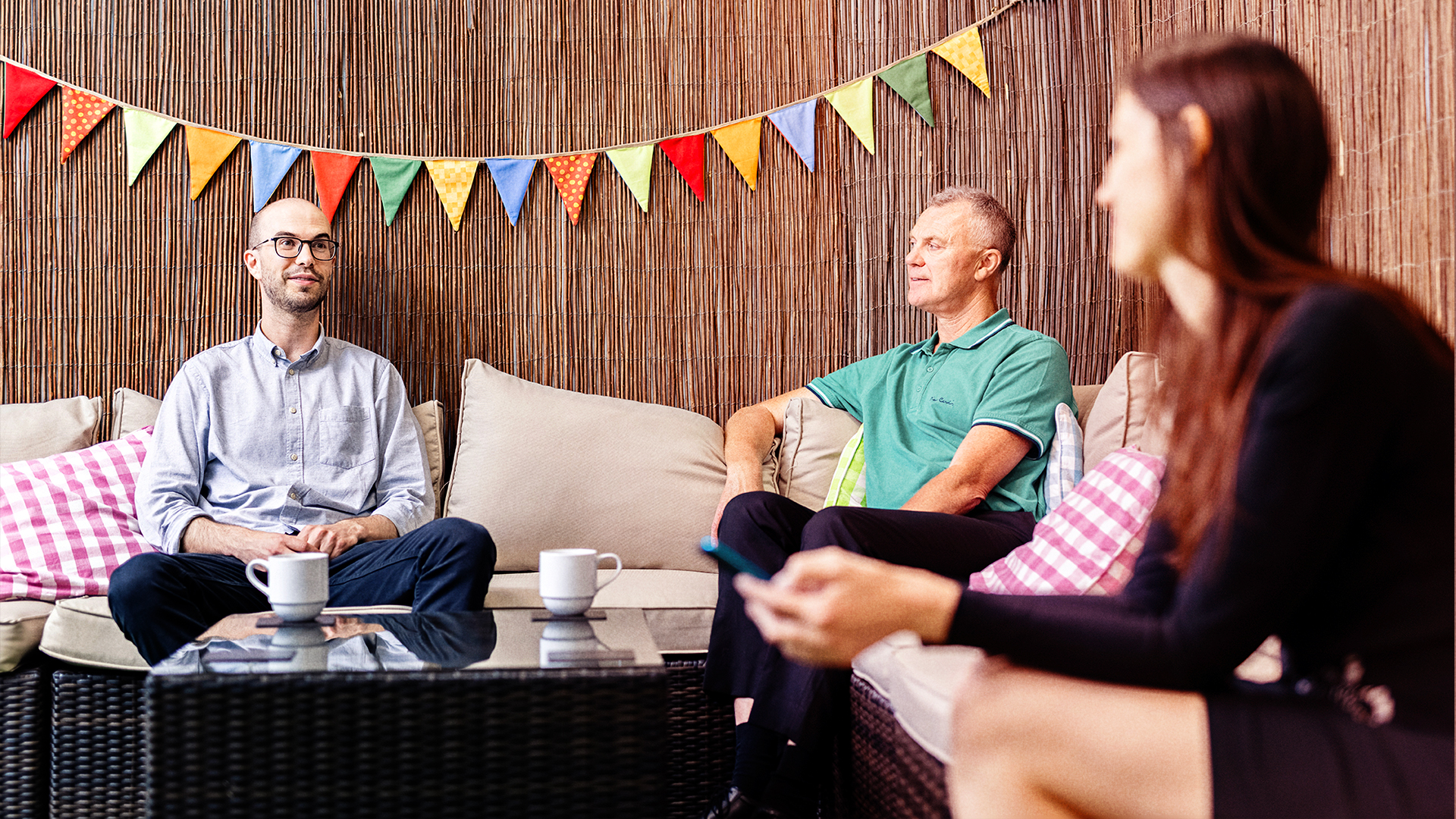 Three people sitting on sofas