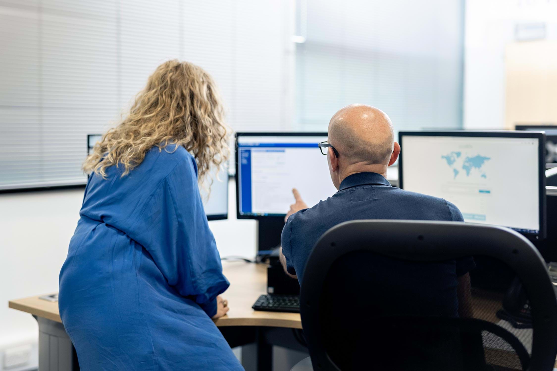 Two people looking at a computer screen 