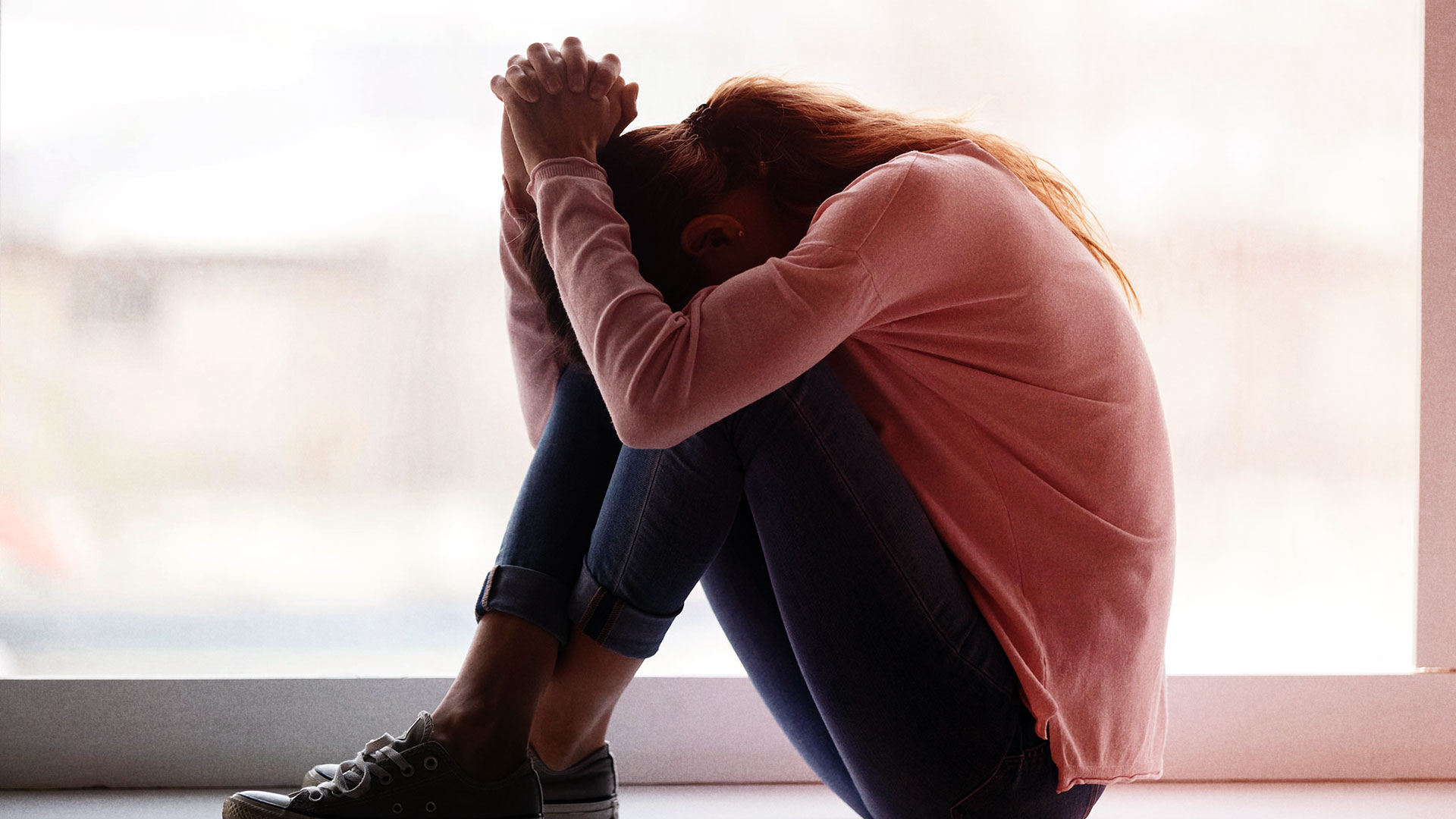 Sad girl with head in hands